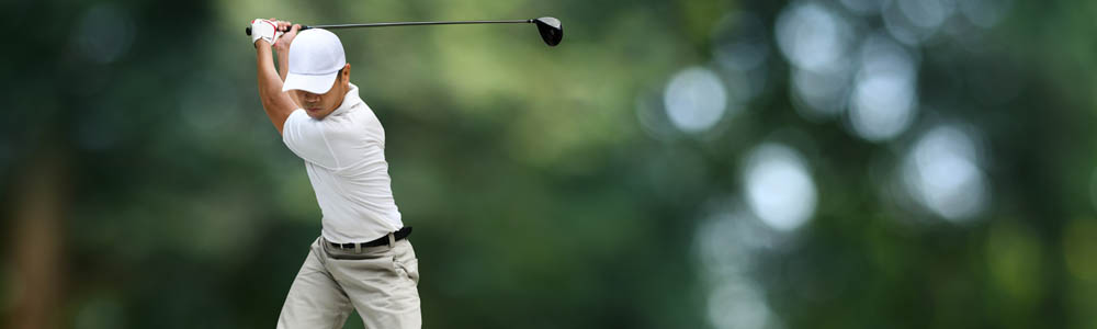Man preparing to drive a ball off the golf tee Man preparing to drive a ball off the golf tee